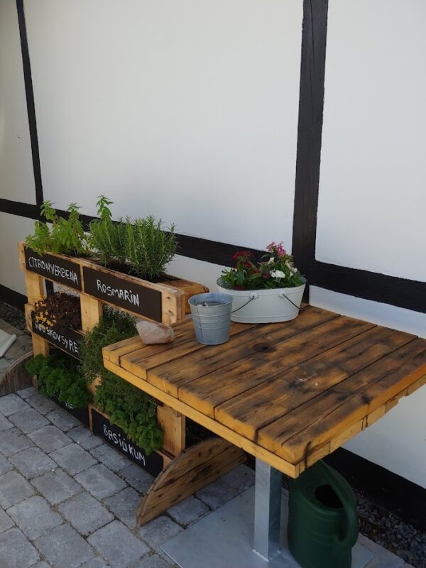 Cafebord af kabeltromle samt rumdeler af paller på Orø Strandcamping
